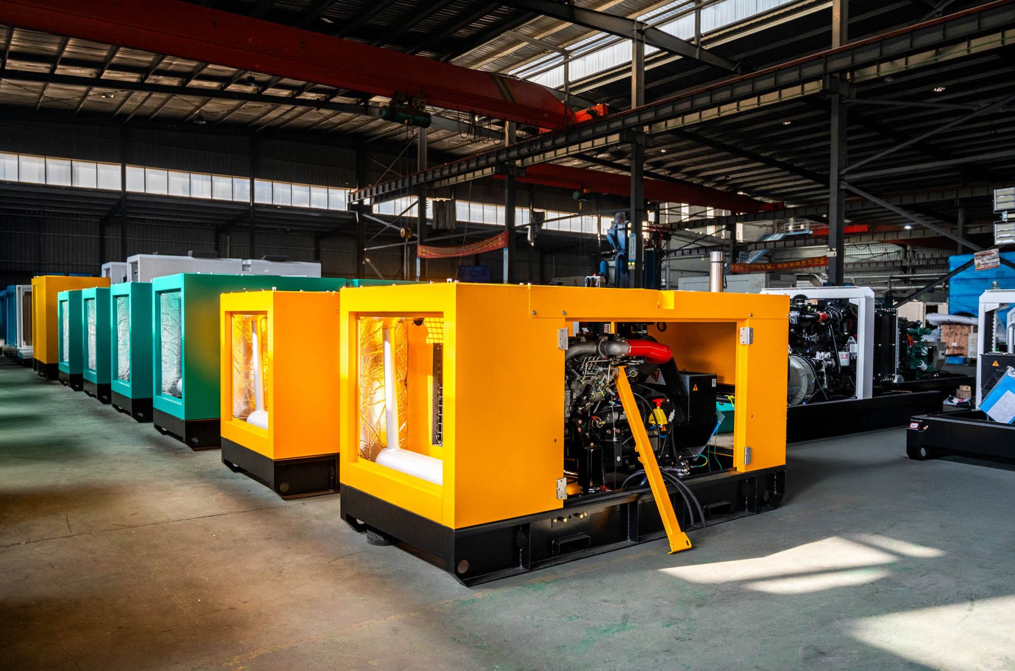 High-performance yellow and green soundproof canopy diesel generator sets lined up inside a modern manufacturing plant, demonstrating large factory production capacity.